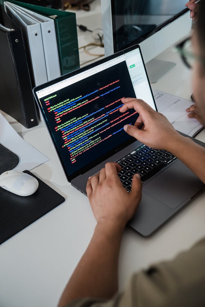 Close up of a Man Pointing Code on a Laptop Screen